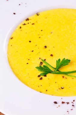 Kremalı Mısır çorbası biber, yeşil soğan ve maydanoz ile süslenmiş beyaz kase