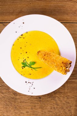 Kremalı Mısır çorbası biber, yeşil soğan ve maydanoz ile süslenmiş beyaz kase