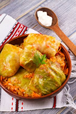 Etli lahana dolması bırakır. Lahana et, pilav ve sebze ile alır. Dolma, sarma, sarmale, golubtsy veya golabki