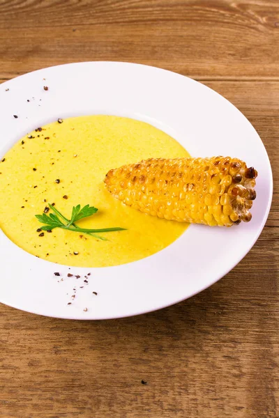 Creamy corn soup in white bowl, garnished with pepper, scallion and parsley — Stock Photo, Image