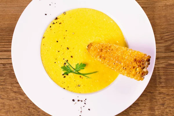 Sopa de milho cremosa em tigela branca, decorada com pimenta, cebolinha e salsa — Fotografia de Stock