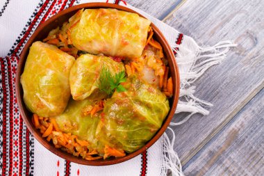 Etli lahana dolması bırakır. Lahana et, pilav ve sebze ile alır. Dolma, sarma, sarmale, golubtsy veya golabki