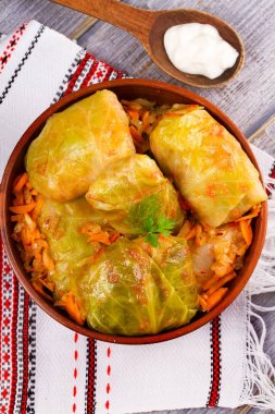 Etli lahana dolması bırakır. Lahana et, pilav ve sebze ile alır. Dolma, sarma, sarmale, golubtsy veya golabki