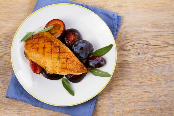 Roast duck brest with plums on white plate — Stock Photo, Image