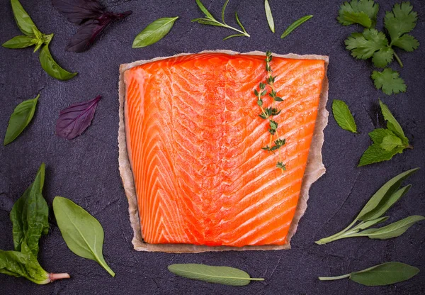 Fresh raw salmon fillet with sage, mint, spinach, cilantro, thyme and rosemary — Stock Photo, Image