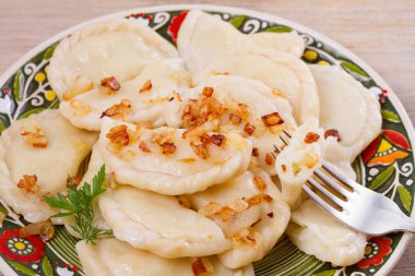 Köfte, patates ile dolu ve tuzlu karamelize soğan ile servis edilir. Varenyky, vareniki, pierogi, pyrohy