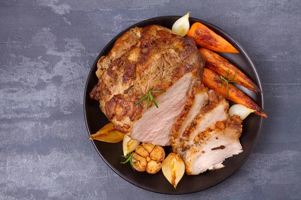 Geroosterde gesneden ham met groenten en vork, mes op grijze rustieke achtergrond — Stockfoto