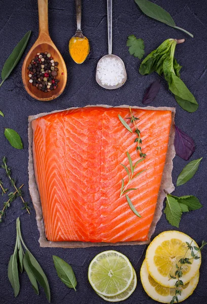 Fresh raw salmon fillet with lemon, lime, sage, mint, spinach, cilantro, thyme and rosemary — Stock Photo, Image