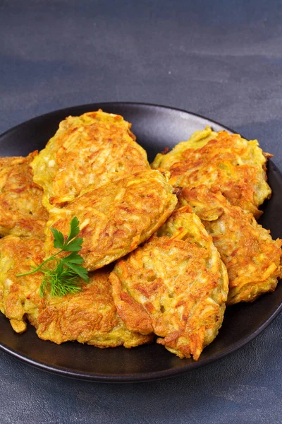 Potato Pancakes. Vegetable fritters. Latkes on black plate — Stock Photo, Image