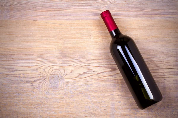 Bottiglia di vino su fondo rustico in legno . — Foto Stock