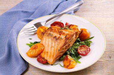 Ispanak ve beyaz tabakta domates ile Somon fileto