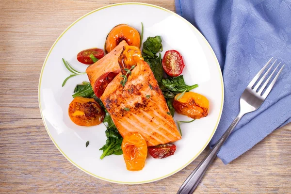 Ispanak ve beyaz tabakta domates ile Somon fileto