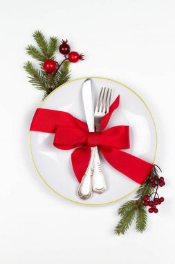 Noel sofra tabak, çatal bıçak takımı, Çamın dalları, şerit ve kırmızı meyveler ile yer. Kış tatili ve festival arka plan. Noel arifesi Akşam Yemeği, yılbaşı yiyecek Öğle Yemeği