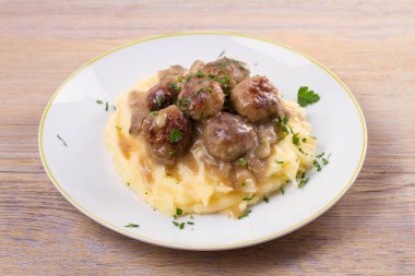 Mantar sos ve patates püresi beyaz tabakta levrek