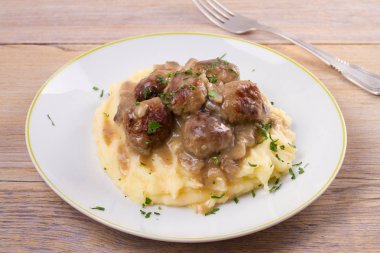 Mantar sos ve patates püresi beyaz tabakta levrek