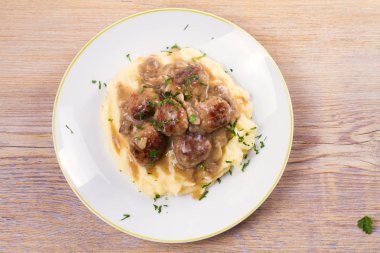 Mantar sos ve patates püresi beyaz tabakta levrek