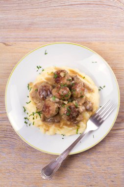 Mantar sos ve patates püresi beyaz tabakta levrek