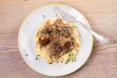 Mantar sos ve patates püresi beyaz tabakta levrek