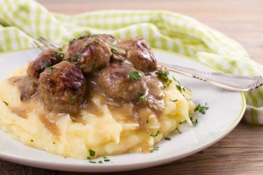 Mantar sos ve patates püresi beyaz tabakta levrek