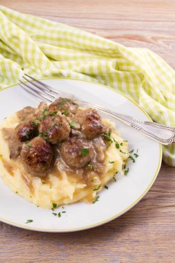 Mantar sos ve patates püresi beyaz tabakta levrek