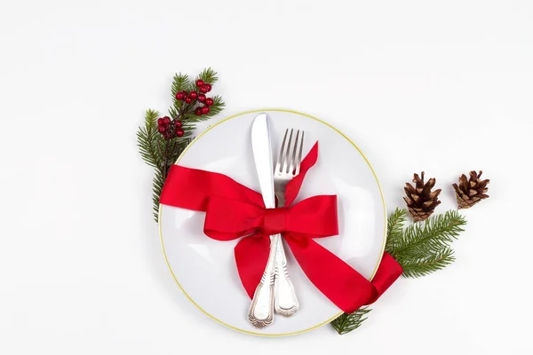 Local de mesa de Natal com prato, talheres, ramos de pinho, fita e bagas vermelhas. Férias de inverno e fundo festivo. Jantar de véspera de Natal, almoço de comida de Ano Novo — Fotografia de Stock