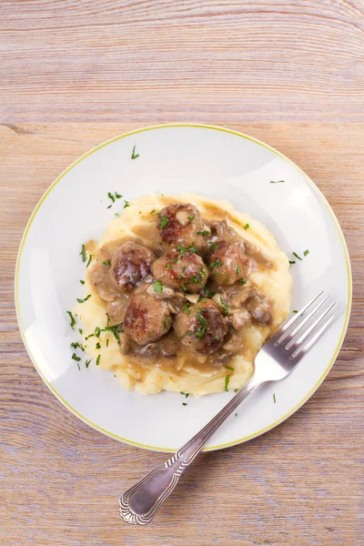 Mantar sos ve patates püresi beyaz tabakta levrek