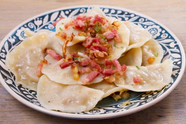 Köfte, lahana ile dolu ve kızarmış domuz pastırması ve soğan ile servis. Varenyky, vareniki, pierogi, pyrohy - Doğu Avrupa'nın popüler çanak