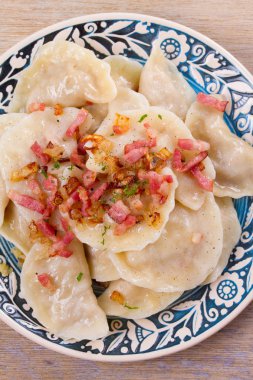 Köfte, lahana ile dolu ve kızarmış domuz pastırması ve soğan ile servis. Varenyky, vareniki, pierogi, pyrohy - Doğu Avrupa'nın popüler çanak