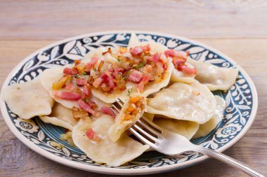 Köfte, lahana ile dolu ve kızarmış domuz pastırması ve soğan ile servis. Varenyky, vareniki, pierogi, pyrohy - Doğu Avrupa'nın popüler çanak