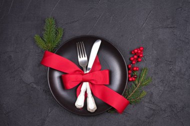 Tabak, çatal bıçak takımı, kırmızı kurdele ve çilek ile Noel tablo ayarı. Kış tatili ve festival arka plan. Noel arifesi Akşam Yemeği, yılbaşı yiyecek öğle yemeği. Yukarıdan görüntülemek, top, yatay