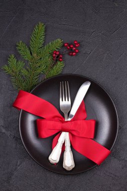 Tabak, çatal bıçak takımı, kırmızı kurdele ve çilek ile Noel tablo ayarı. Kış tatili ve festival arka plan. Noel arifesi Akşam Yemeği, yılbaşı yiyecek öğle yemeği. Yukarıdan görüntülemek, top, dikey