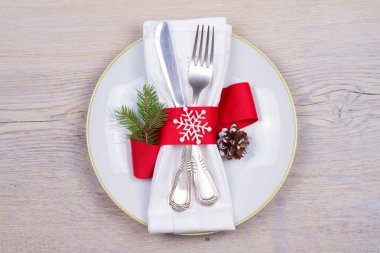 Tabak, çatal bıçak takımı ve kırmızı kurdele ile Noel tablo ayarı. Kış tatili ve festival arka plan. Noel arifesi Akşam Yemeği, yılbaşı yiyecek öğle yemeği. Yukarıdan görüntülemek, top, yatay