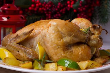 Bütün kızarmış tavuk ya da hindi patates, limon ve limes Noel ve yeni yıl arka planda, yatay
