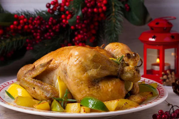 Whole roasted chicken or turkey with potatoes, lemons and limes on Christmas and New Year background, horizontal