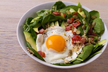 Quinoa ile avokado, pastırma, ıspanak ve beyaz kase kabak çekirdeği yumurta. Kahvaltı, yatay için ideal çanak