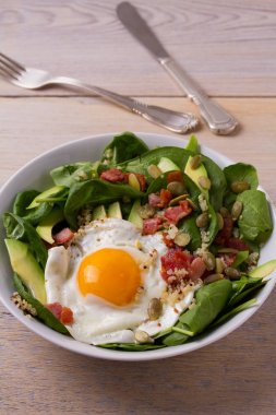 Quinoa ile avokado, pastırma, ıspanak ve beyaz kase kabak çekirdeği yumurta. Kahvaltı, dikey için ideal çanak