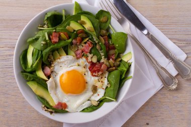 Quinoa ile avokado, pastırma, ıspanak ve beyaz kase kabak çekirdeği yumurta. İdeal yemek kahvaltı için. Yukarıdan görüntülemek, top, yatay
