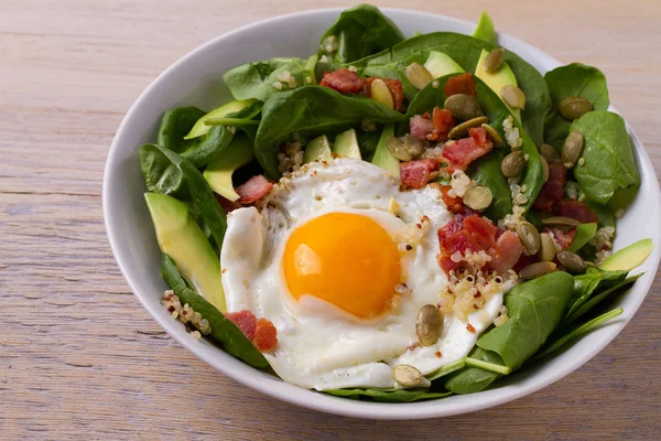 Quinoa ile avokado, pastırma, ıspanak ve beyaz kase kabak çekirdeği yumurta. Kahvaltı, yatay için ideal çanak