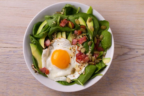 Quinoa ile avokado, pastırma, ıspanak ve beyaz kase kabak çekirdeği yumurta. İdeal yemek kahvaltı için. Yukarıdan görüntülemek, top, yatay