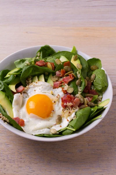 Quinoa ile avokado, pastırma, ıspanak ve beyaz kase kabak çekirdeği yumurta. Kahvaltı, dikey için ideal çanak