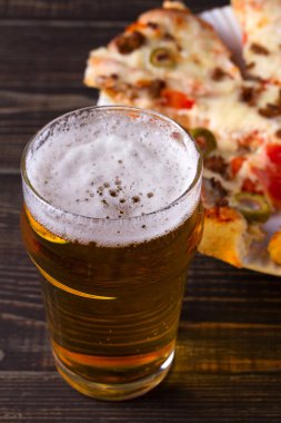Bira ve pizza koyu ahşap arka plan üzerinde. Ale ve gıda