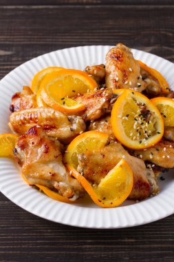 Susam ile portakal tavuk kanatları. Yukarıdan görüntülemek, top, dikey