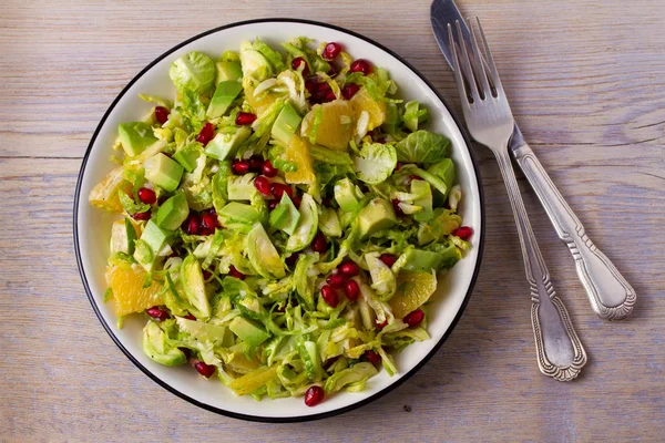 Brussels Sprouts Pomegranate, Avocado, and Citrus Salad. View from above, top, horizontal