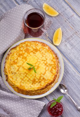 Yığın ince krep, krep beyaz tabakta, fincan çay ve meyve reçeli, ek yükü