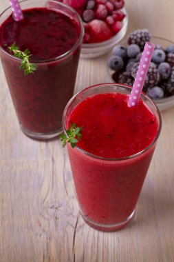 Donmuş yaz meyve güler yüzlü: yaban mersini, çilek, ahududu, kızılcık, kuş üzümü ve böğürtlen ahşap arka plan, dikey