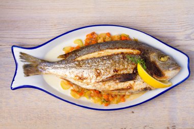 Bütün kılıçbalığı veya dorada balık sebze, kekik ve limon ile. Yukarıdan görüntülemek, top, yatay