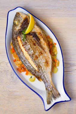 Bütün kılıçbalığı veya dorada balık sebze, kekik ve limon ile. Yukarıdan görüntülemek, top, dikey 
