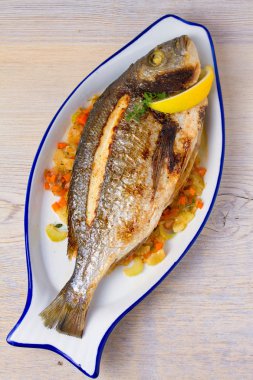 Bütün kılıçbalığı veya dorada balık sebze, kekik ve limon ile. Yukarıdan görüntülemek, top, dikey 