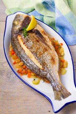 Bütün kılıçbalığı veya dorada balık sebze, kekik ve limon ile. Yukarıdan görüntülemek, top, dikey 