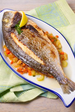 Bütün kılıçbalığı veya dorada balık sebze, kekik ve limon, dikey
